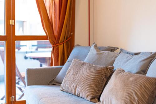 a couch with pillows sitting in a living room at Martesana Terrace Flat with garage - Ospedale San Raffaele in Vimodrone
