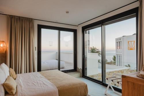 a bedroom with a bed and a view of the ocean at MiFlow Hotel Villas & Suites in Miami Platja