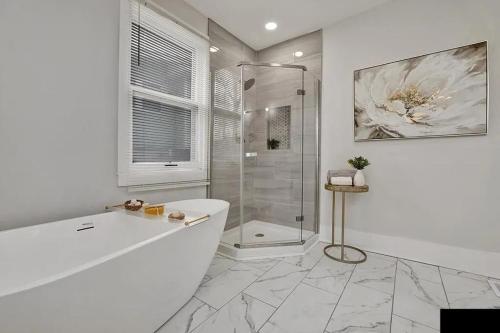 a white bathroom with a shower and a tub at Optimum - Uptown Oasis in Birmingham