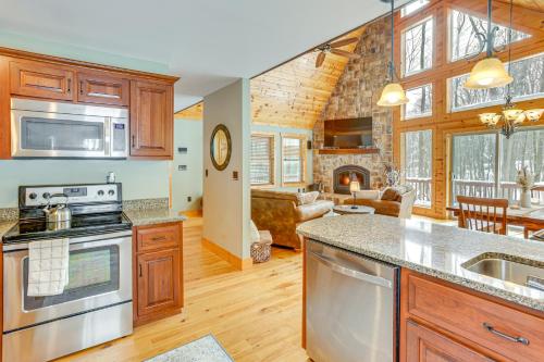 a kitchen with a stove top oven next to a living room at Hike, Ski and Raft Terra Alta Cabin with Large Deck in Terra Alta