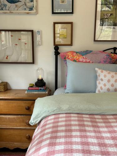 a bedroom with a bed and a wooden dresser with a bed sidx sidx sidx at The Milking Shed in Kurrajong