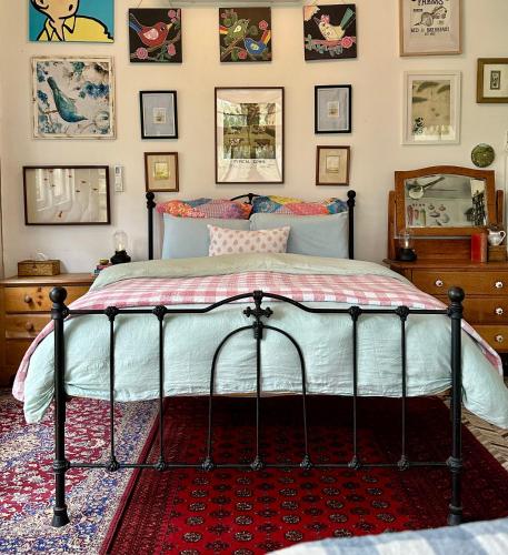 a bed in a bedroom with pictures on the wall at The Milking Shed in Kurrajong