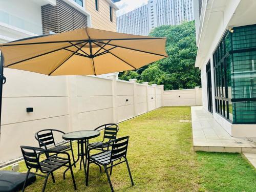 a table and chairs with an umbrella on the side of a building at New Sea Breeze Landed Home 13pax BatuFerrigghi in Batu Ferringhi