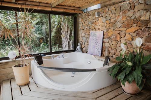 a bath tub in a room with a stone wall at Aloe Village Aparthotel & Spa in La Paloma