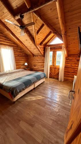 a large bedroom with a bed in a log cabin at La Estancia in Trevelín