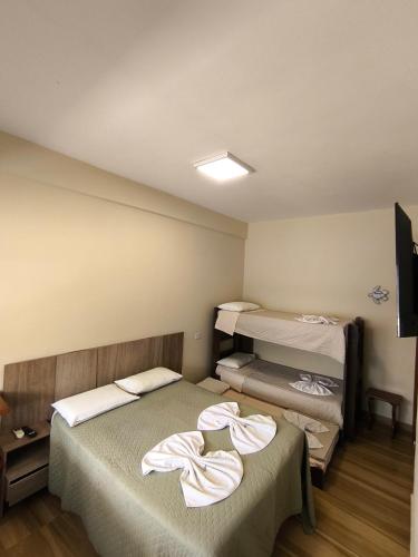 ein Zimmer mit zwei Betten mit Handtüchern darauf in der Unterkunft Canto Sul Suítes in Ubatuba