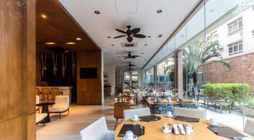 a restaurant with tables and chairs and a large window at APTO Top com Vista pro Mar em Condomínio Completo em Frente à Praia! in Santos