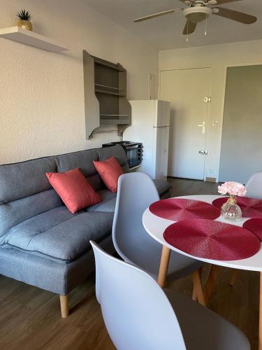 un salon avec un canapé et une table dans l'établissement Agréable appartement avec loggia, WIFI & parking proche plage, à Saint Cyprien Plage