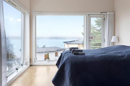 a bedroom with a bed and a large window at Spectacular Villa - Pool, Sauna & Magical Lake View in Lidingö