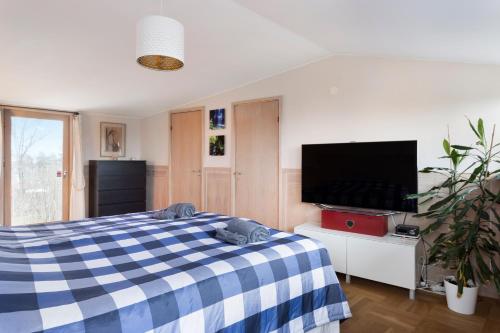 a bedroom with a blue and white checkered bed at Spectacular Villa - Pool, Sauna & Magical Lake View in Lidingö