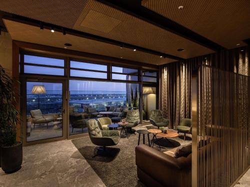 a living room with furniture and a view of the city at b'mine Hotel Frankfurt Airport in Frankfurt/Main