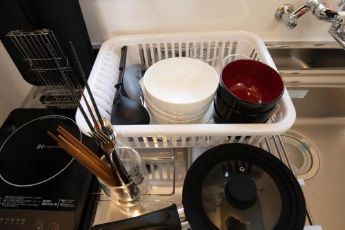 a dish rack with dishes and utensils in a kitchen at lol 3 101 in Hakodate