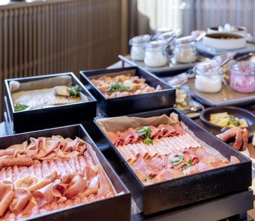 a buffet with many trays of different types of food at b'mine Hotel Frankfurt Airport in Frankfurt/Main