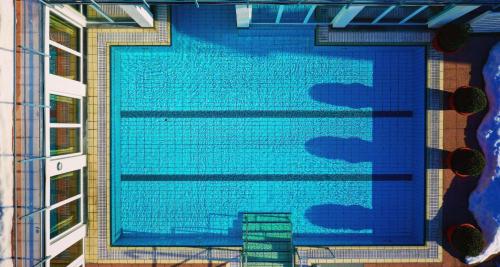 a large blue swimming pool on the side of a building at Wellness-& Nationapark Hotel Schliffkopf, BWSC in Baiersbronn