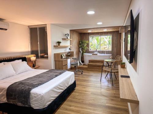 a bedroom with a bed and a bathroom with a tub at Edificio Atalanta en el corazón de Medellín in Medellín