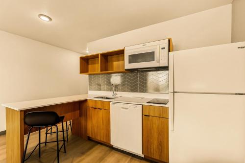 a small kitchen with a refrigerator and a microwave at LivAway Suites Salt Lake City- West Jordan in West Jordan