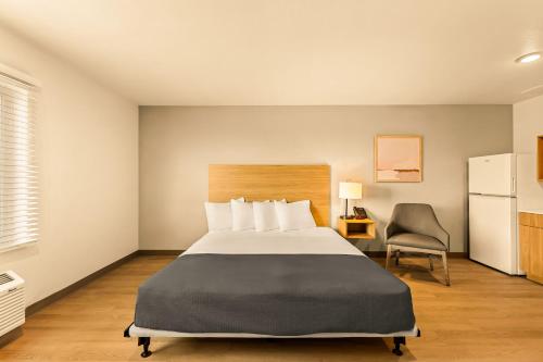 a hotel room with a bed and a chair at LivAway Suites Salt Lake City- West Jordan in West Jordan