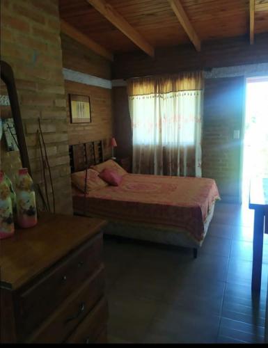 a bedroom with a bed and a dresser in a room at Mono Complejo Cóndor in Mina Clavero