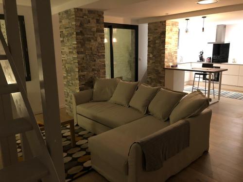 un salon avec un canapé et une cuisine dans l'établissement T3 Duplex Design - Pau Centre Quartier Halles, à Pau