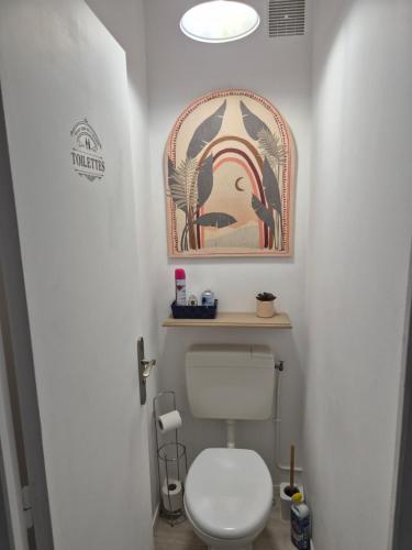 a bathroom with a toilet and a picture on the wall at Welcome Becs! in Saint-Hilaire-de-Riez
