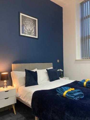 a bedroom with two beds with blue walls at Doncaster Penthouse Long Stays in Doncaster