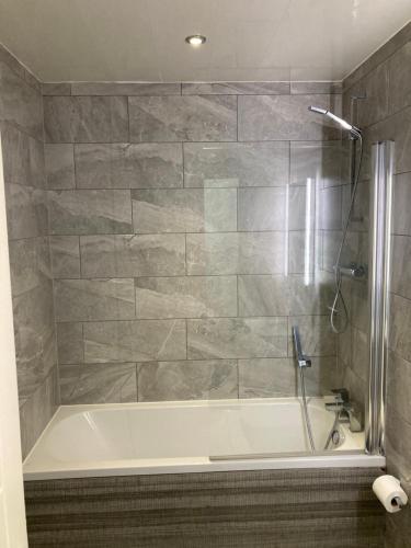 a bathroom with a bath tub with a shower at Doncaster Penthouse Long Stays in Doncaster
