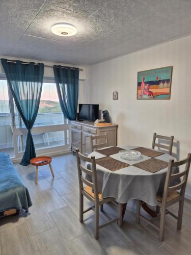 une salle à manger avec une table, des chaises et une télévision dans l'établissement Welcome Becs!, à Saint-Hilaire-de-Riez