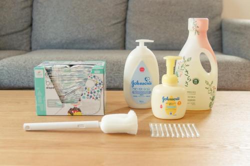 a table with bottles of detergents and a comb at Lapacho 子どもが絶対満足する宿 民泊らぱちょ in Kumamoto