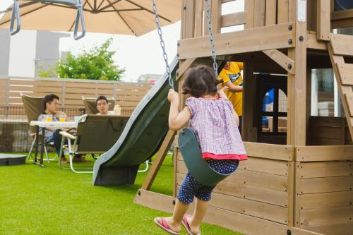 a little girl on a swing in a playground at Lapacho 子どもが絶対満足する宿 民泊らぱちょ in Kumamoto