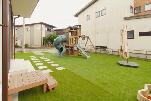 a backyard with a playground with a slide at Lapacho 子どもが絶対満足する宿 民泊らぱちょ in Kumamoto