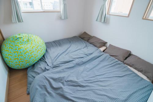 a bed with a blue comforter in a bedroom at Lapacho 子どもが絶対満足する宿 民泊らぱちょ in Kumamoto