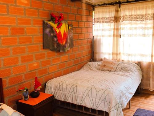 a brick walled bedroom with a bed in a room at Hospedaje Valentina para ti y tu familia in Mera
