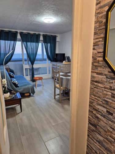 a living room with a couch and a table and a desk at Welcome Becs! in Saint-Hilaire-de-Riez