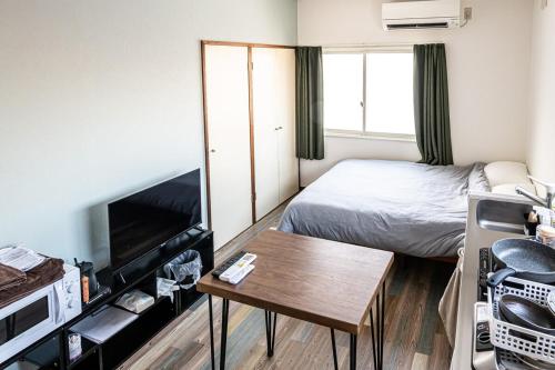 a small bedroom with a bed and a table at lol 3 201 in Hakodate