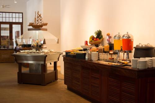 a buffet in a restaurant with food on a counter at Nilaveli Beach Hotel in Nilaveli