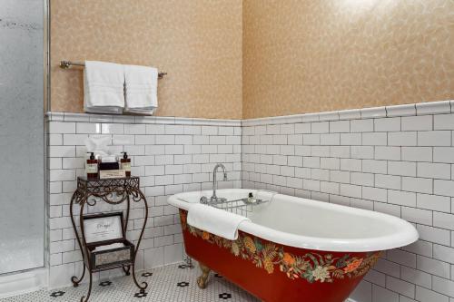 a bath tub in a bathroom with white tiles at Beaumont Hotel and Spa - Adults Only in Ouray