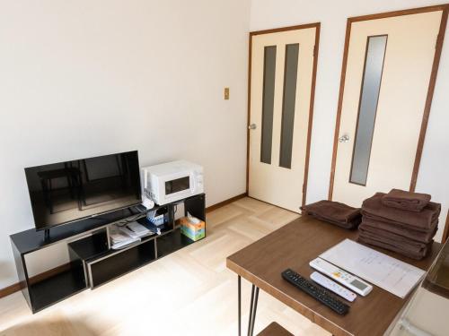 a living room with a table and a tv and a microwave at lol 3 202 in Hakodate