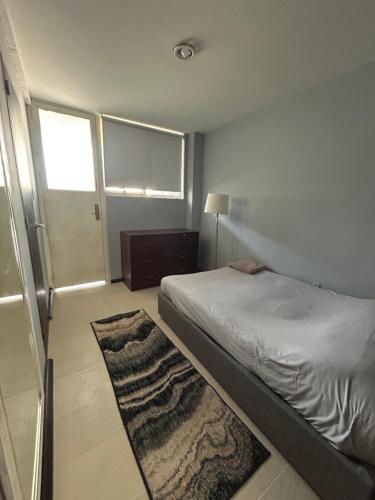 a small bedroom with a bed and a rug at Luxury Apartment Masaryk 4BR in Mexico City