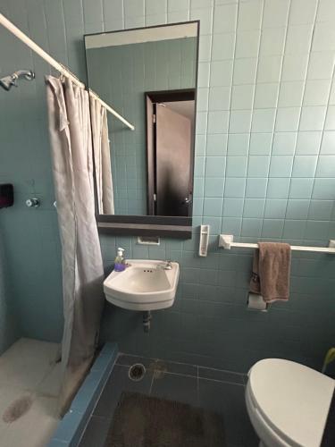 a bathroom with a sink and a mirror and a toilet at Luxury Apartment Masaryk 4BR in Mexico City