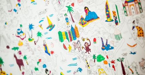 a wall covered in drawings of different countries at The Caravan in Thessaloniki