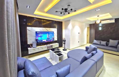 a living room with a couch and a tv at Cozy Ambience 2 in Ibadan
