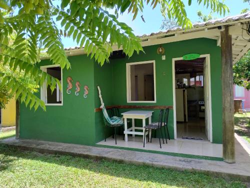 a green house with a table and chairs at Aquarela Village - Barra Grande in Marau
