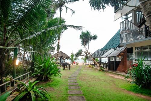 a street in a village with palm trees and a building at Sea Trails Bentota in Bentota