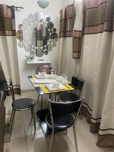 a dining room with a table and chairs and curtains at Marthe Appartement in Cotonou