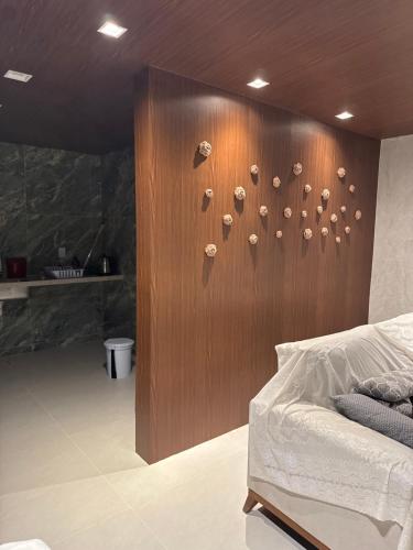 Un dormitorio con una pared de madera con rocas. en Suites em mansão, en Fortaleza
