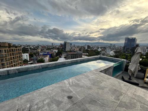 a swimming pool on the roof of a building at Increíbles departamentos en Roma Norte in Mexico City