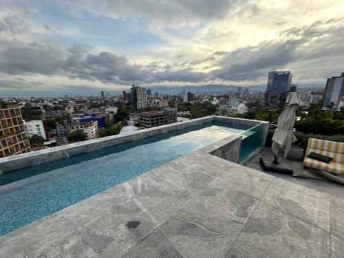 a swimming pool on the roof of a building at Increíbles departamentos en Roma Norte in Mexico City