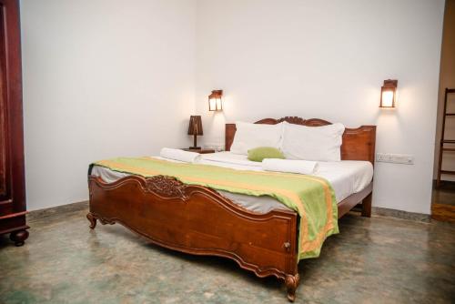 a bedroom with a wooden bed with white pillows at Sea Trails Bentota in Bentota