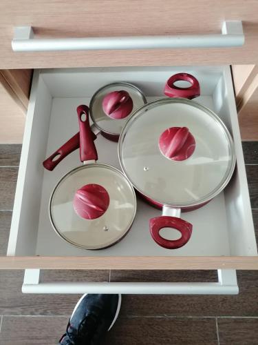 a table with two pans and red utensils at Playa Blanca Ocean in Río Hato