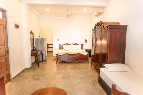 a bedroom with a bed and a dresser in it at Sea Trails Bentota in Bentota